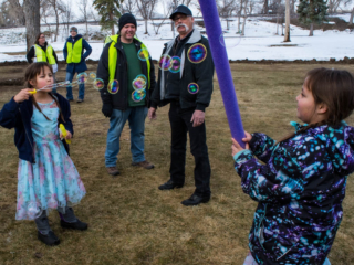 Kids in the park blowing bubbles with Set Free volunteers in the background