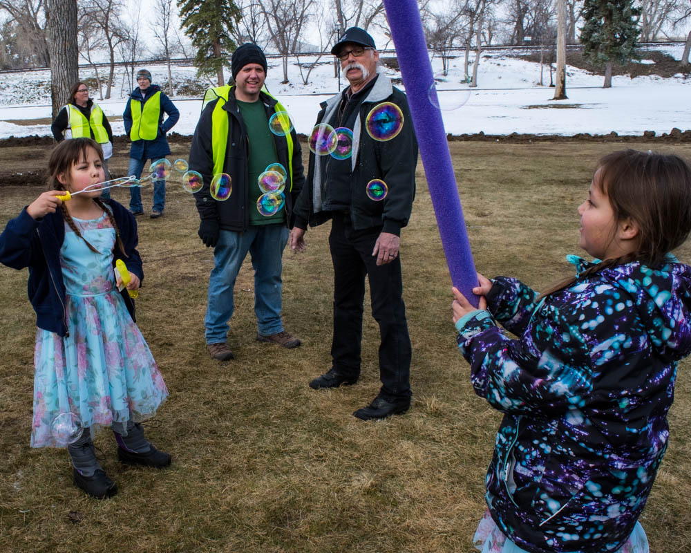 Kids in the park blowing bubbles with Set Free volunteers in the background