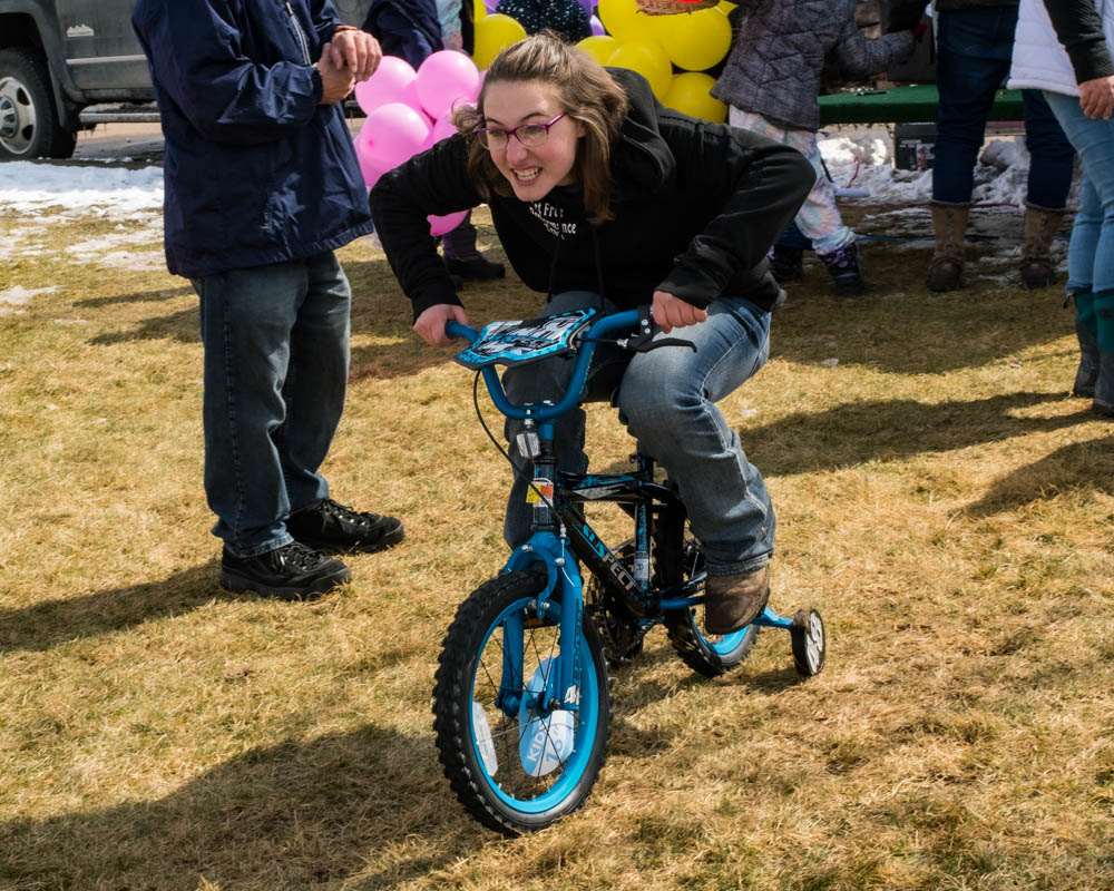 teenage girl on small bike with training wheels